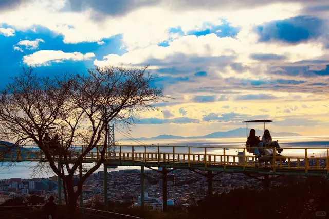 空中脚踏车轨道横在山顶，背后是明石海峡大桥和海