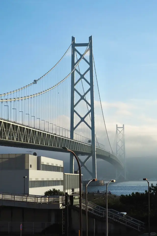 明石海峡大桥主塔与横跨海面的桥身，远塔没入海雾
