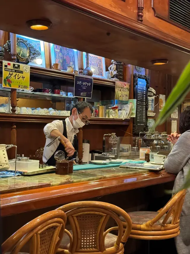 昭和风木质吧台，店主在虹吸壶前煮咖啡